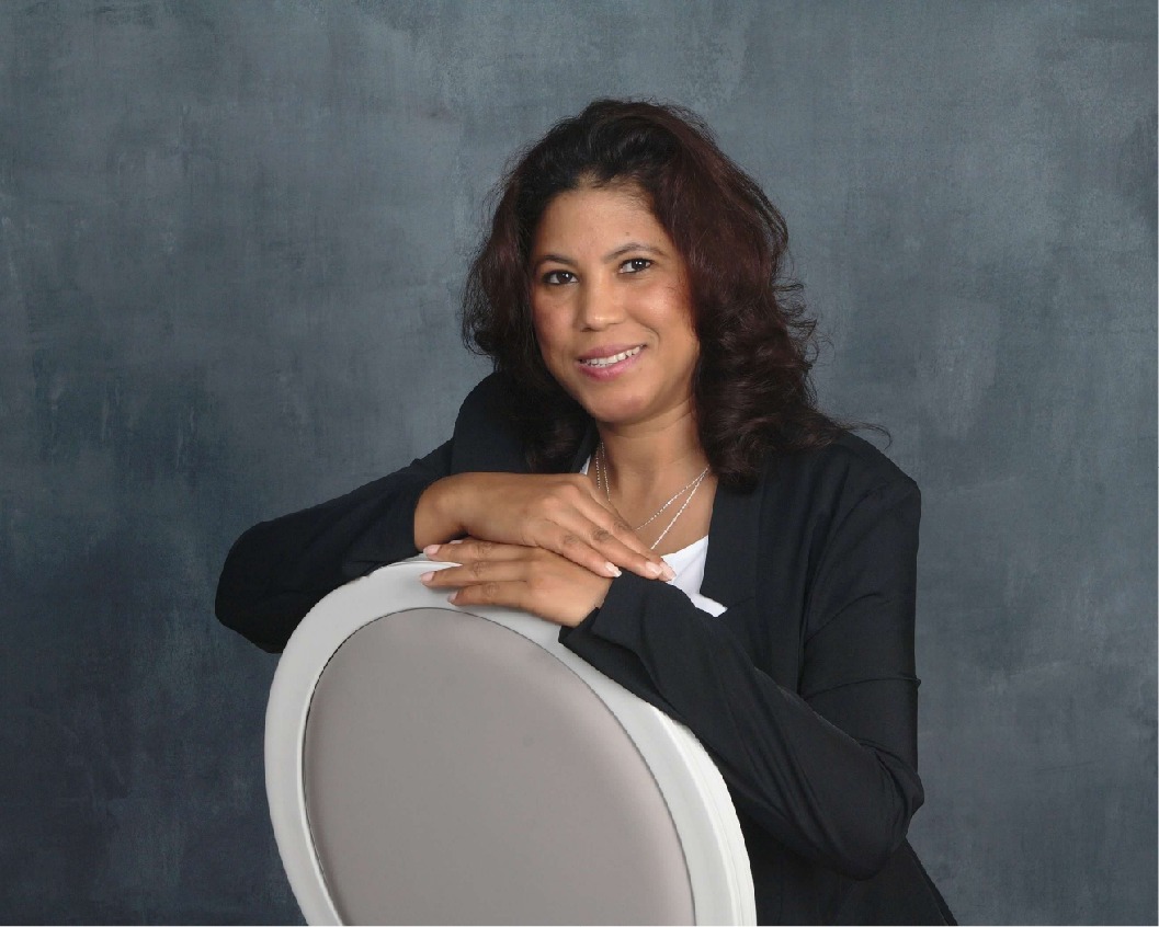 Ysaura Inoa seated in a black suit, calm and confident